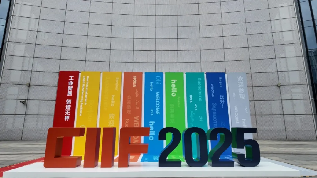 Vibrant "CIIF 2025" metal sculpture on white base, with colorful banners saying "WELCOME" and exhibition themes in multiple languages